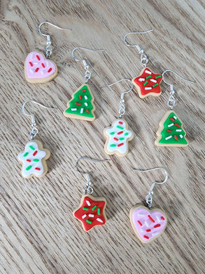 Handmade Christmas cookie earrings in polymer clay featuring hearts, stars, trees, and gingerbread men with icing and sprinkles, festive holiday jewelry.