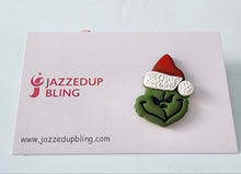 Load image into Gallery viewer, Handmade Grinch Christmas brooch with green face and Santa hat – quirky festive accessory.
