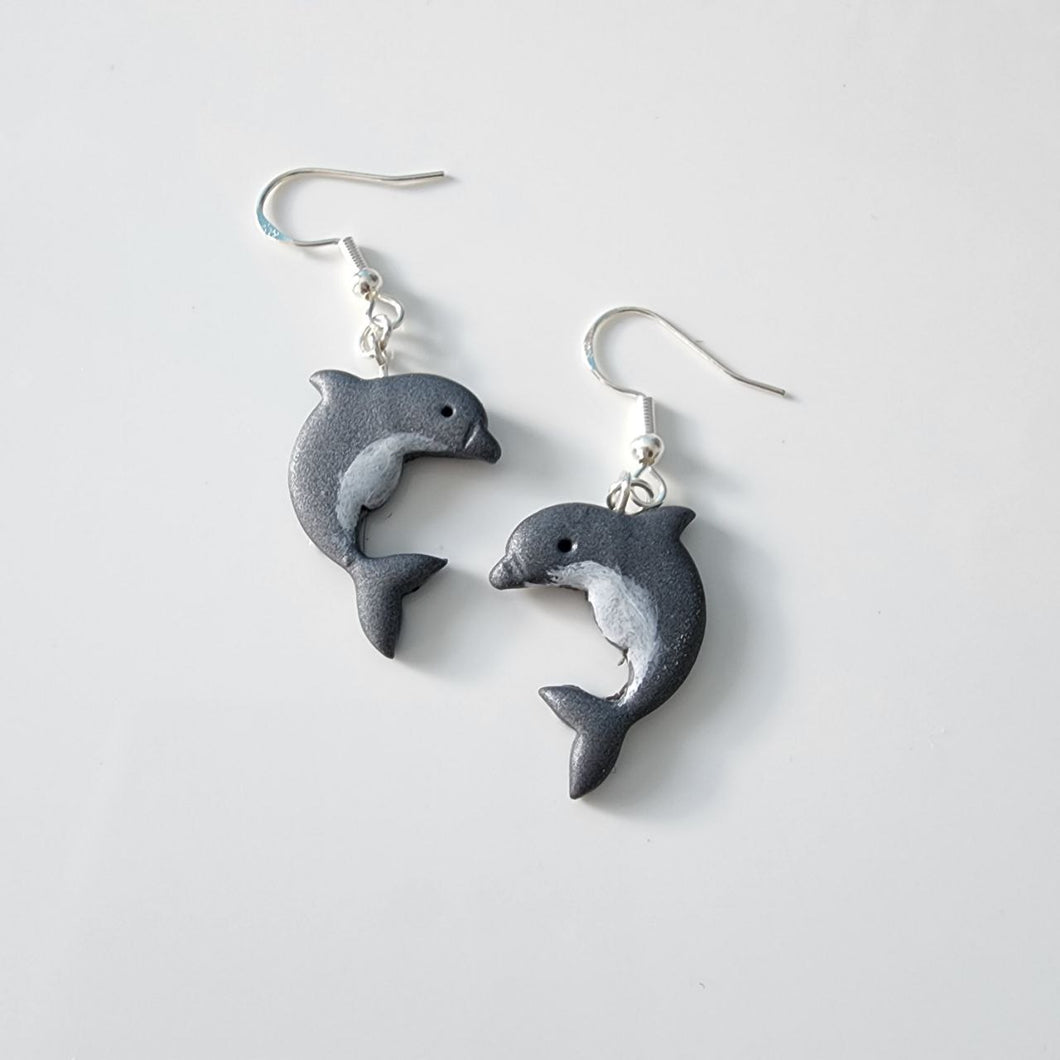 “Handmade polymer clay dolphin earrings in grey and white, displayed on a white background – ocean animal jewellery made in New Zealand”