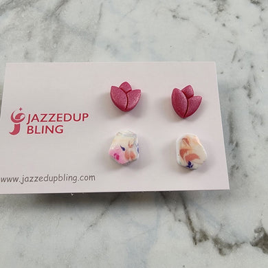 Two pairs of stud earrings, one rose-shaped and one pastel marble pattern.