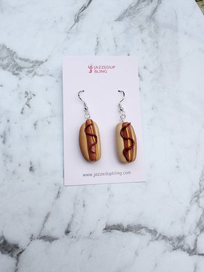 Realistic hot dog earrings with bun and sauce detail