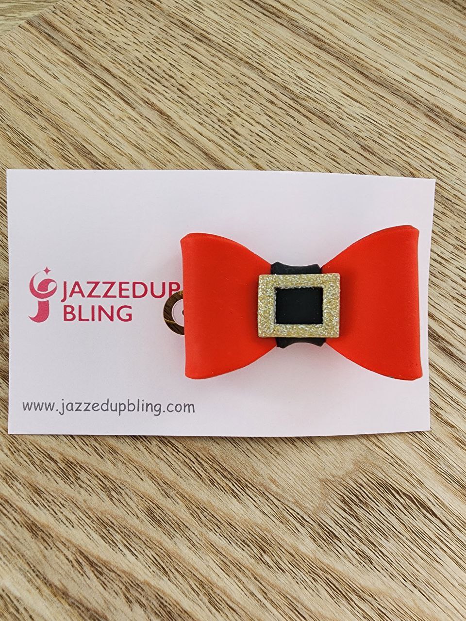 Handmade Santa belt bow hair clip with red bow and glittery gold buckle – festive Christmas accessory by Jazzed Up Bling NZ