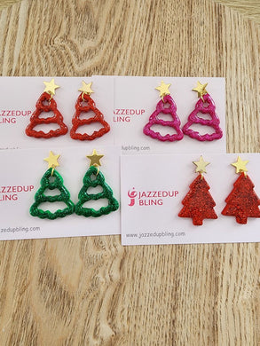 Handcrafted sparkling Christmas tree earrings in red, green, and pink with gold star tops on display cards by Jazzed Up Bling.