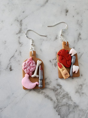 Handmade Spooky Feast Halloween earrings with brains, bones, and creepy details on chopping boards – polymer clay jewelry NZ.