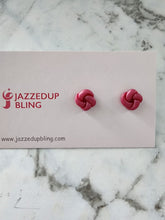 Load image into Gallery viewer, Handmade polymer clay knot stud earrings in deep berry pink.
