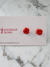 Load image into Gallery viewer, Bold red polymer clay knot earrings with lively handcrafted detail.
