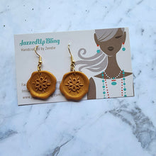 Load image into Gallery viewer, Handmade gold polymer clay wax seal earrings with snowflake design by Jazzed Up Bling.
