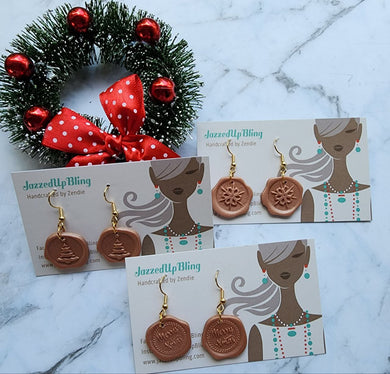 Collection of handmade wax seal Christmas earrings with snowflake, tree, and Merry Xmas designs by Jazzed Up Bling.