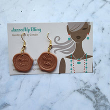 Load image into Gallery viewer, Handmade polymer clay wax seal earrings with Merry Xmas design by Jazzed Up Bling.
