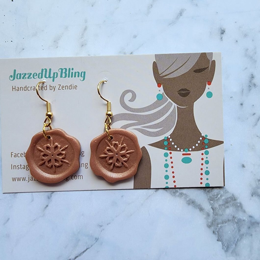 Handmade polymer clay wax seal earrings with snowflake design by Jazzed Up Bling.